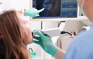 Dentist and patient examine intraoral photos